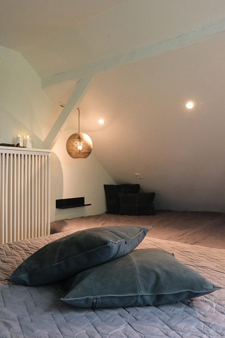 Lækre ruskindspuder i et nordisk udtryk pynter i Volleshave Airbnb soveværelse.