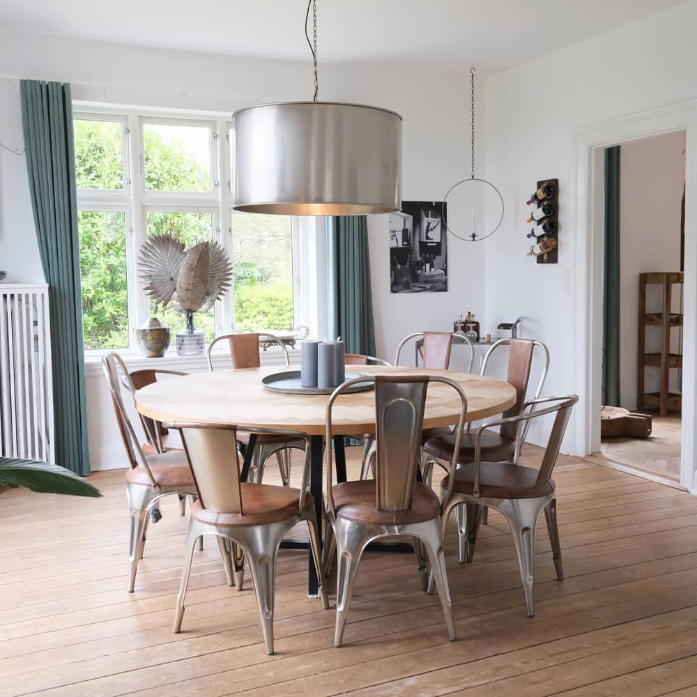 Rundt spisebord med metalstole, rå indretning til Airbnb i Volleshave.