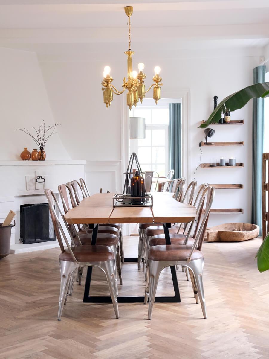 Spiseplads i Airbnb med lang plankebord og industrielle stole i metal og læder.